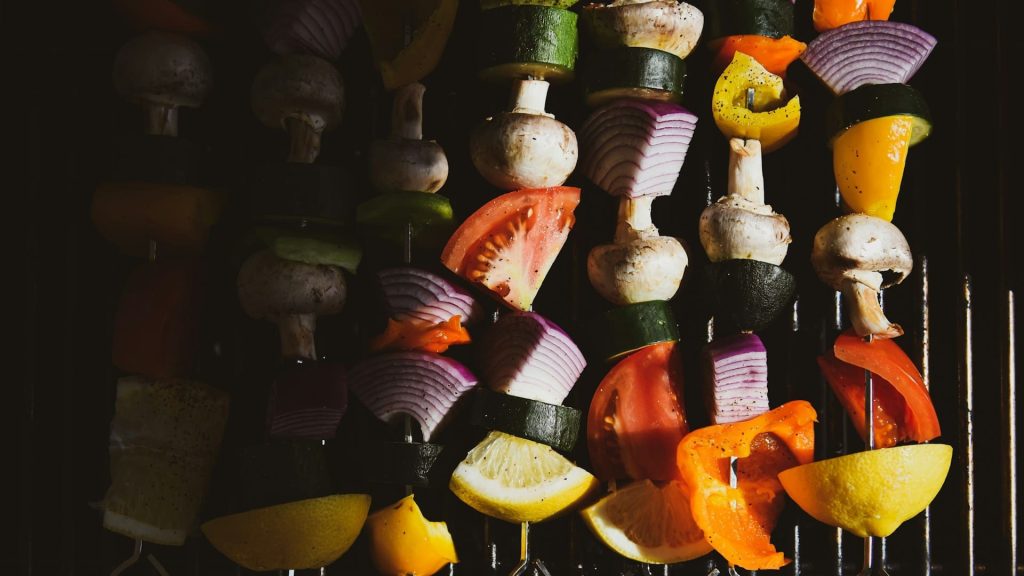 Gegrilde groenten bereiden op spiesjes met paprika, ui, champignon en courgette op de barbecue.