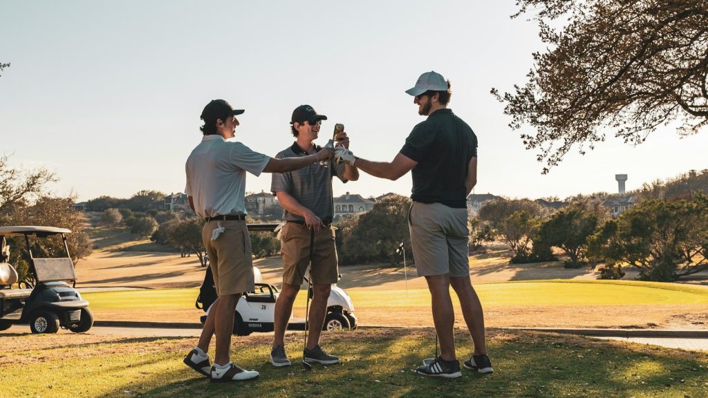 Drie golfers proosten met drankjes, voeding tijdens golfen versterkt sociale beleving