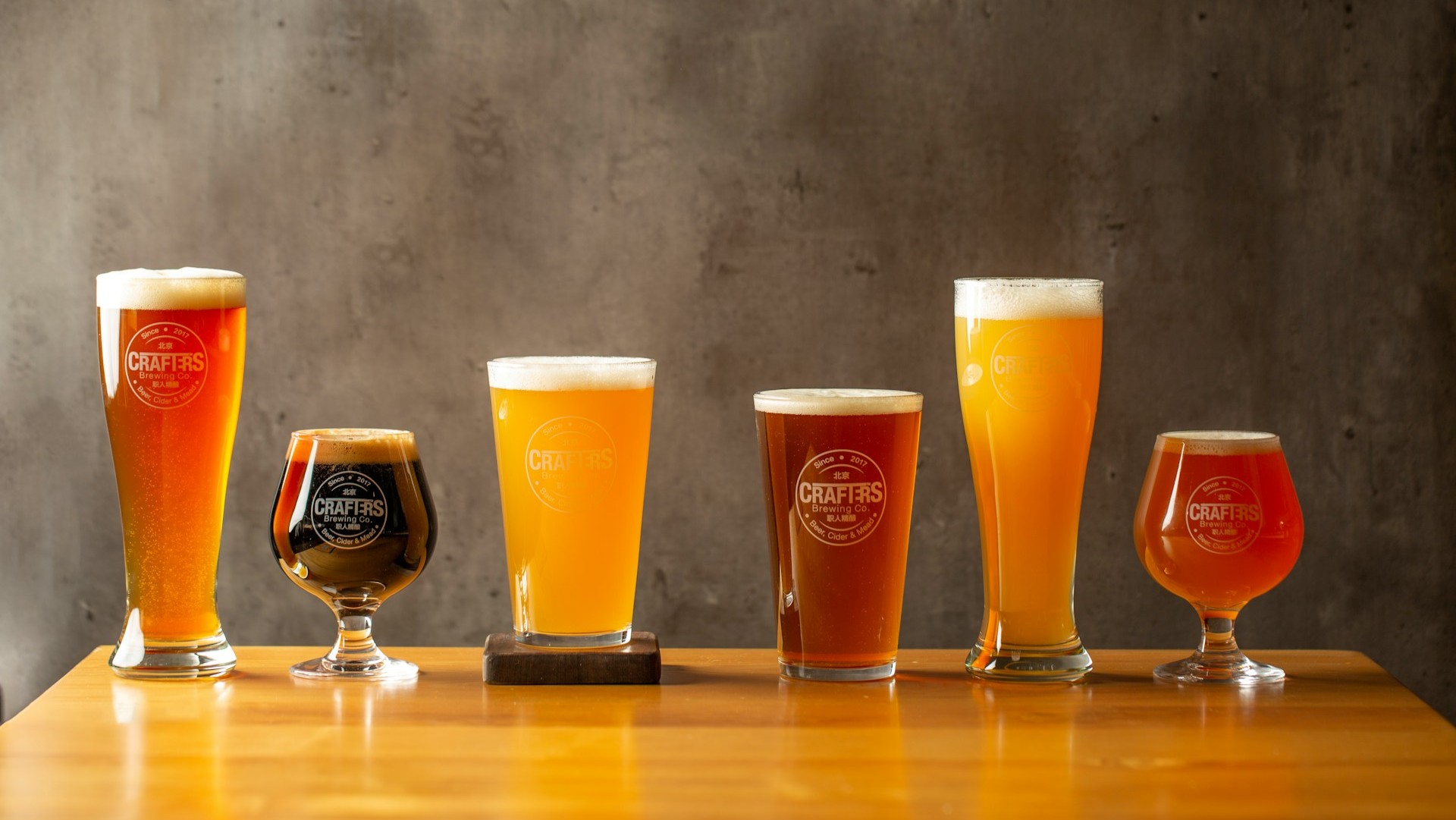 Diverse ambachtelijke bieren van lokale makers in verschillende glazen op een houten tafel