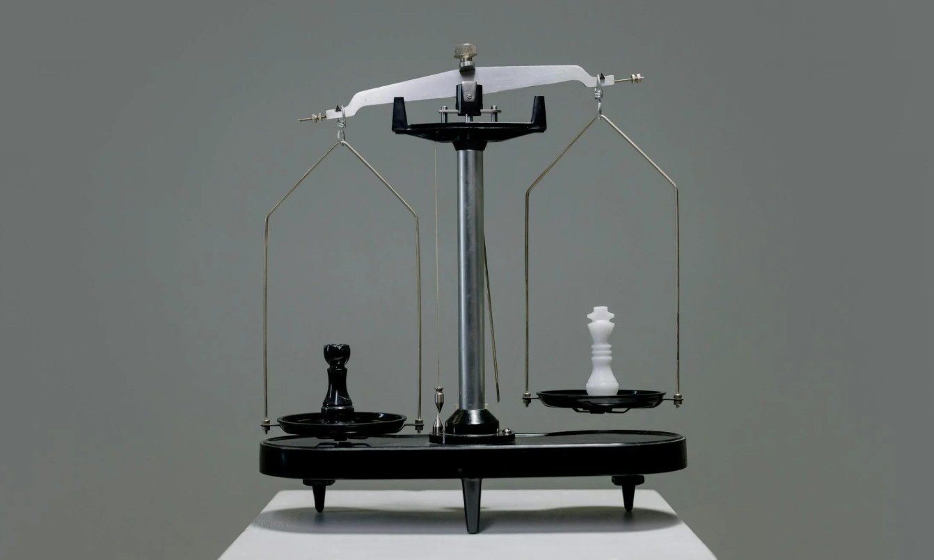 Zwarte balans weegschaal met witte en zwarte schaakstukken die ongelijkheid en balans tonen