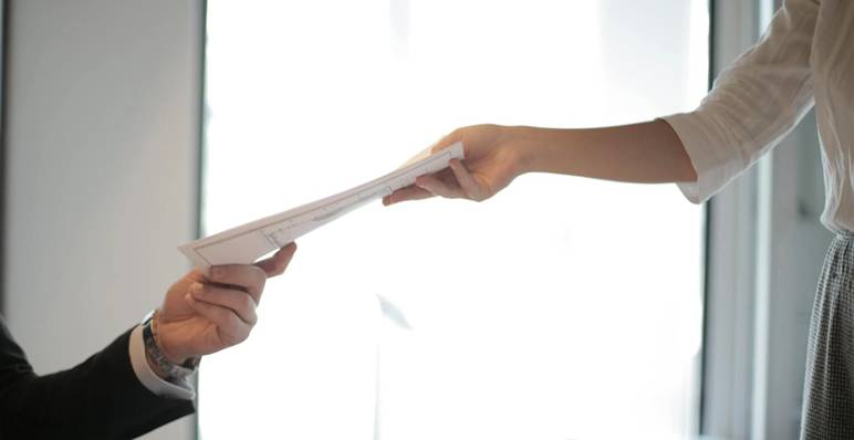 Sollicitant overhandigt cv aan restaurantmanager tijdens sollicitatie