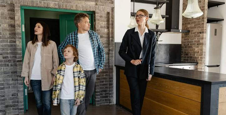 Gezin bekijkt samen met makelaar een leegstaand pand als mogelijke locatie om een restaurant te starten.