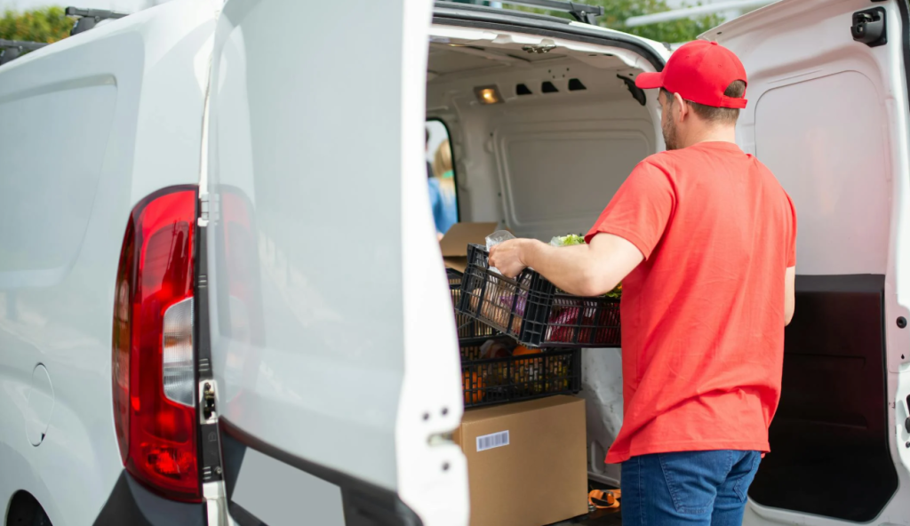 Leverancier lost grote levering met kratten uit bestelbus, essentieel moment bij restaurantlogistiek